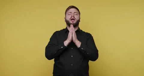 Embracing gratitude with hands together in front of a bright yellow backdrop Vidéo 329110969