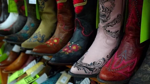 Embroidered cowboy boots lined up on store shelf. Close detail of floral and Stock Footage 336339218