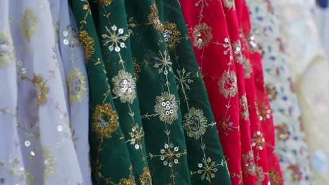 Embroidered fabrics with gold thread ornamental patterns displayed in row Stock Footage 344996015