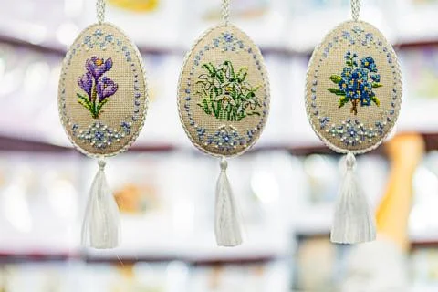 Embroidered floral Easter decorations, featuring intricate blue, green, pur.. Stock Photos