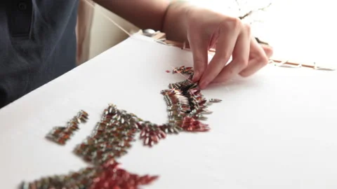 The embroiderer embroiders large beads and sequins. The fabric is hooped Stock Footage 146261841