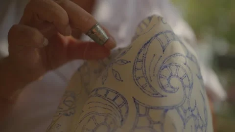 Embroiderer following blue pattern on cloth sewing with needle and thread, Stock Footage 256286865