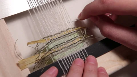The embroiderer manually weaves a small piece of decorative fabric Stock Footage 146262163