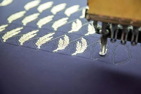 Embroidery machine creating feather designs on fabric Stock Photos