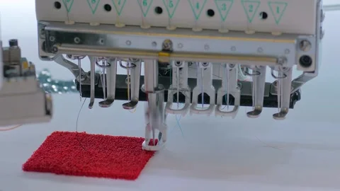 Embroidery machine is creating red decorative textile pattern on the fabric Stock Footage 347242998