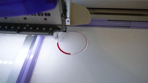 Embroidery machine in the process of embroidering company logo on uniform in tex Stock Footage 295184562