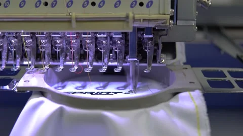 Embroidery machine in progress embroidery company logo on uniform in Textile  Stock Footage