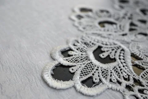 Embroidery pattern on a white table cloth, abstract detailed backdrop Stock Photos