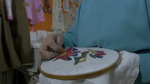 Embroidery by pattern,making traditional design on textile with needle,tilt down Stock Footage 57654101