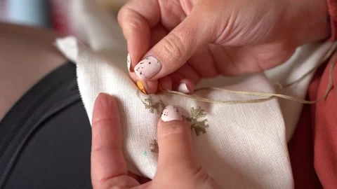 Embroidery techniques on fabric showcasing delicate handwork Stock Footage 317999222