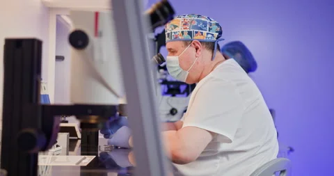 Embryologist in Laboratory. An embryologist uses a microscope and laboratory Stock Footage 276411275