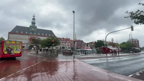 Emden, Germany - August 25, 2026: Red city bus passing the waterfront in Emden Stock Footage 344391691