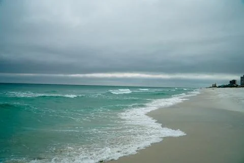 Emerald Coast beach small waves sand and grey skies Stock Photos