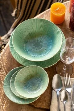 Emerald Green Ceramic Dinnerware Set with Radial Texture on Wood Table Stock Photos