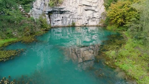 Emerald karst spring surrounded by forest aerial view Stock Footage 327071919