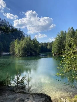 Emerald Lake Surrounded by Cliffs and Forest Stock Photos