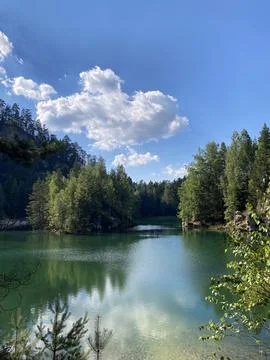 Emerald Lake Surrounded by Cliffs and Forest Stock Photos
