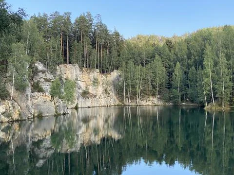 Emerald Lake Surrounded by Cliffs and Forest Stock Photos