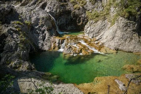 Emerald Mountain Pool and Small Waterfall Flowing Through Rocky Alpine Gorg.. Stock Photos