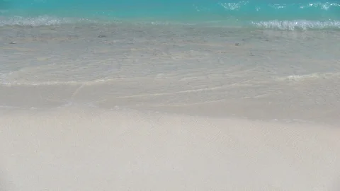 Emerald ocean waves reach sandy beach. Close up. Slow motion 240 fps Stock Footage 119156819