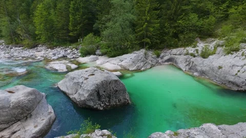 Emerald pool forms within pale limestone rocks at Velika korita Soce gorge in Stock Footage 342290578