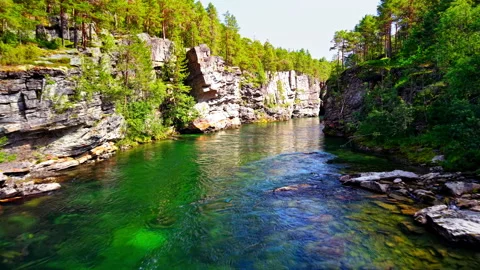 Emerald River beneath Sunlit Cliffs, Oppdal Norway Stock Footage 318537313