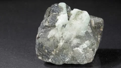 Emerald in rock on a black background. Green mineral beryl. A nugget of close-up 스톡 동영상 141214958