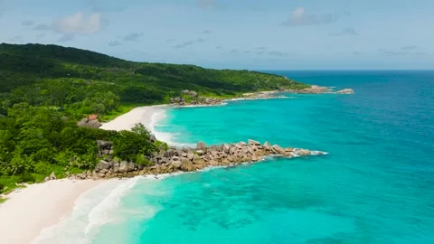 Emerald sea meets white sand beach with rocky headland. Seychelles, La Digue. Stock Footage 310344507