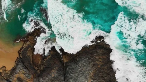 Emerald Surge: Abstract Top-Down Aerial View of Turquoise Waves Against Basalt Stock Footage 340918988