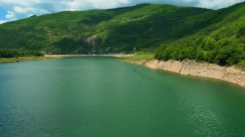 Emerald water flows beneath green hills. Zavoj Lake, Serbia Stock Footage 337491667