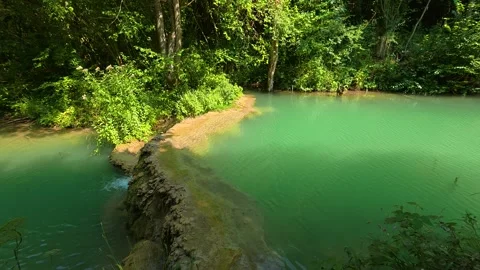 Emerald waters ripple gently beside mossy rocks. Bigar Waterfall, Serbia 動画素材 346249708