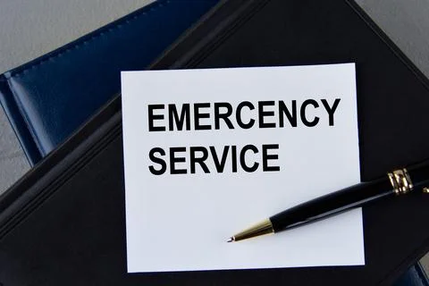 EMERCENCY SERVICE - words on white sheet on a black leather book with pen Stock Photos