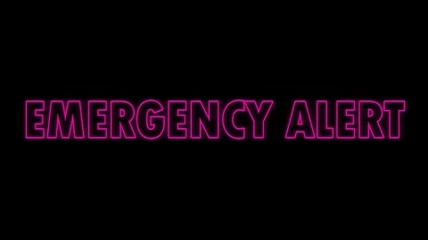 Emergency Alert text flashing in neon pink letters against a dark black Stock Footage 338327135