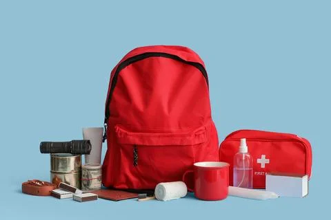 Emergency backpack with necessities on blue background Stock Photos