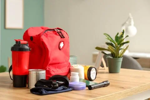 Emergency backpack with necessities on desk in classroom Stock Photos