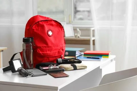 Emergency backpack with necessities on table in classroom Stock Photos