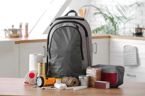 Emergency backpack with necessities on table in kitchen Stock Photos