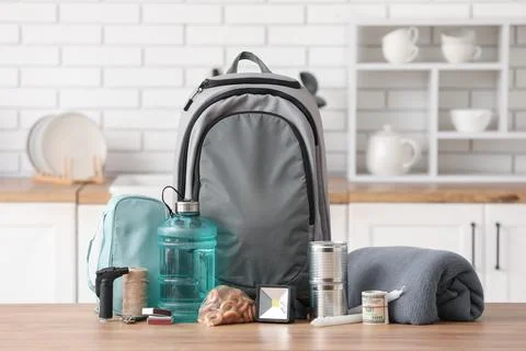 Emergency backpack with necessities on table in kitchen Stock Photos