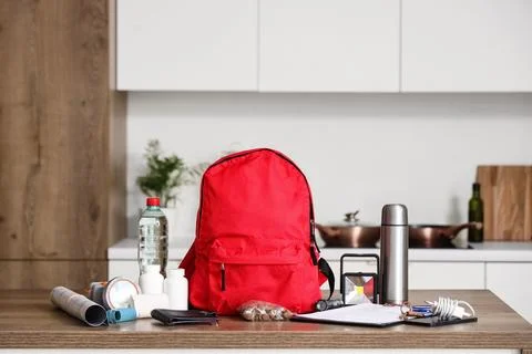 Emergency backpack with necessities on table in kitchen Stock Photos