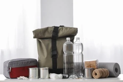 Emergency backpack with necessities on table in room Stock Photos