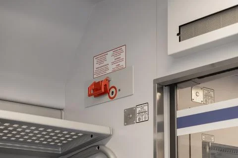 An emergency brake handle inside a passenger train compartment to provide 스톡 사진