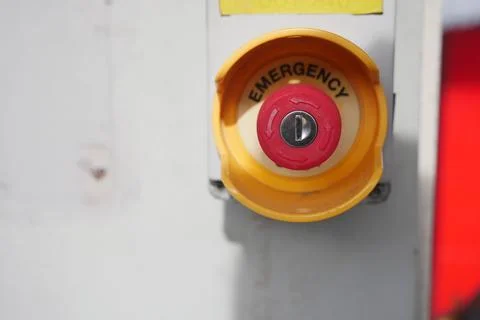 Emergency button on equipment in a workspace area Stock Photos