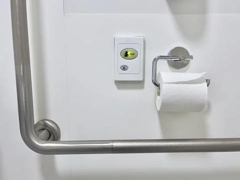 Emergency call button on the wall of a disability-friendly toilet room in a medi Stock Photos