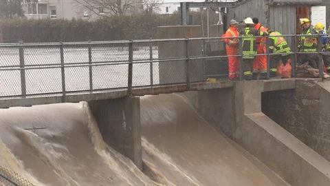 Emergency crews work at dam in flash flooding by river Stock Footage 122674795
