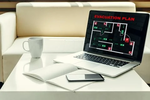 Emergency evacuation plan displayed on a laptop shows safe exits and fire Stock Photos