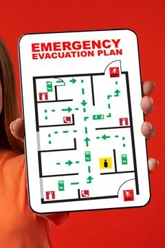 Emergency evacuation plan held by a person showing exit routes and safety Stock Photos