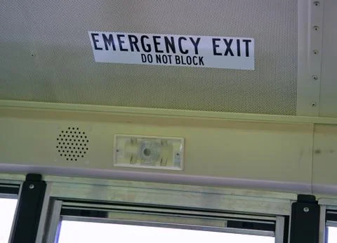 Emergency Exit decal attached to the ceiling of a school bus. Stock Photos