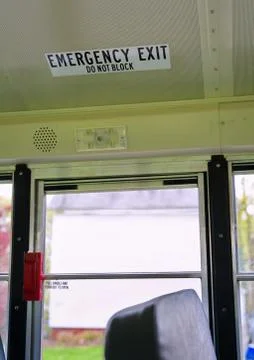 Emergency Exit decal attached to the ceiling of a school bus. Stock Photos