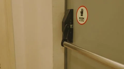 Emergency exit door with push bar and sign in a building. Video stock 343418023