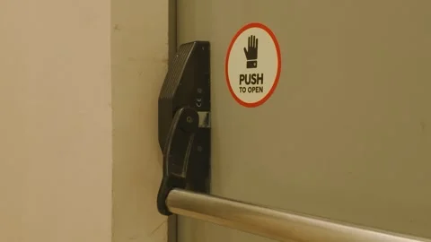 Emergency exit door with push bar and open sign inside building Vidéo 343423981